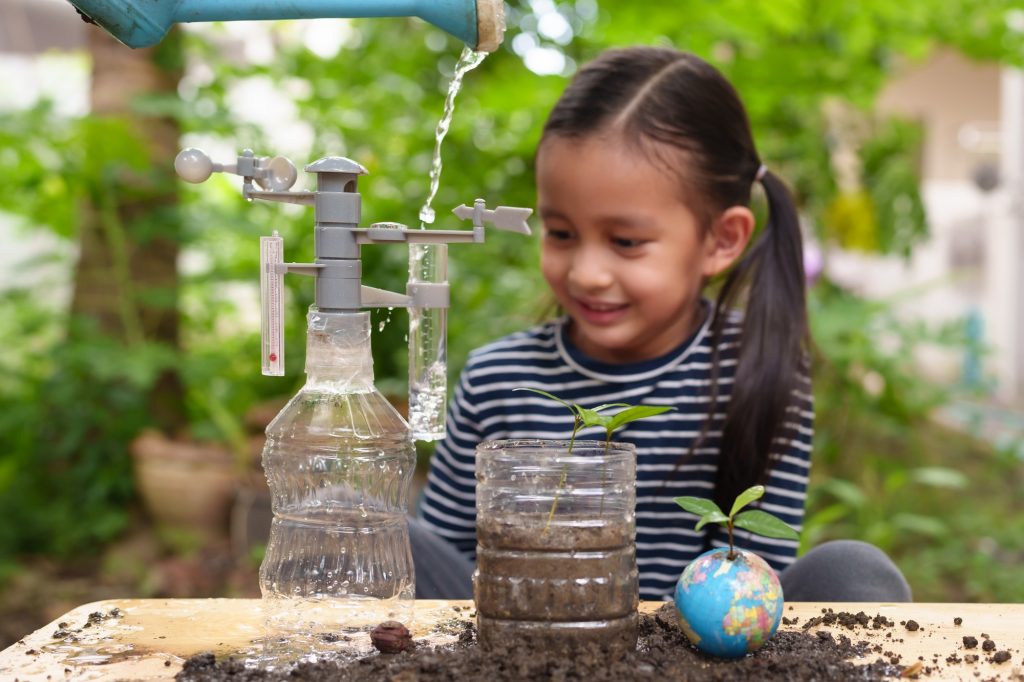 Blurred of little girl is learning science experiment and planting with recycle plastic bottle.