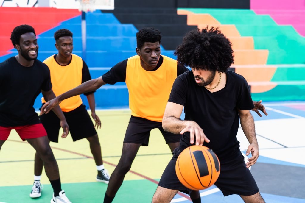 Young friends playing basketball outdoor - Urban sport lifestyle concept